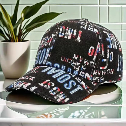 SIGNAL_VANISH_06 Cap | VOIDWEAR Ritual-Inspired Streetwear. Black cap with colorful text pattern on a reflective surface with a plant in the background