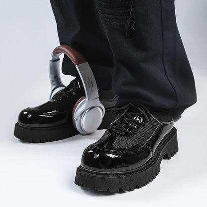 VOIDWEAR men’s ritual-inspired PU leather shoes – minimalist techwear style for U.S. and EU streetwear markets. Black glossy shoes with thick soles worn by a person, with headphones on a white background
